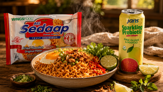 A bowl of Mi Sedaap Original Fried Noodles topped with crispy fried onions, paired with a chilled can of Jans Sparkling Prebiotic