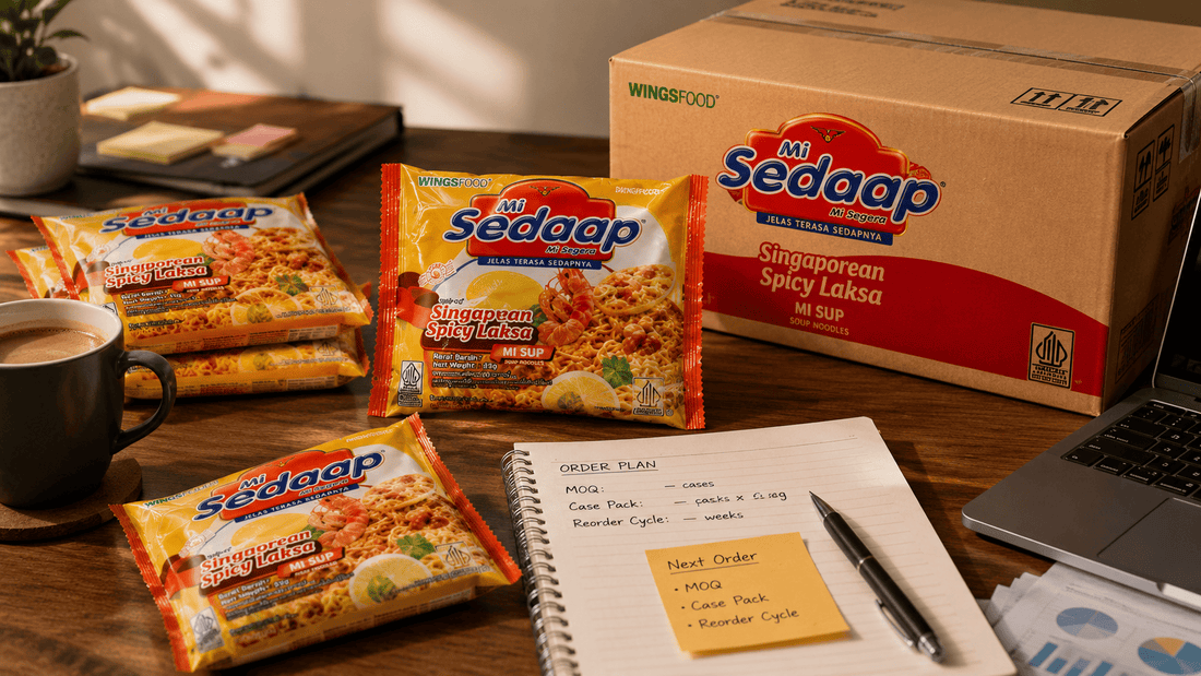 Desk with Mi Sedaap Singaporean Spicy Laksa packets, a wholesale case box, and a notebook labeled Order Plan listing MOQ and reorder cycle.