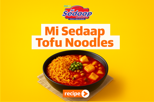 Mi Sedaap tofu noodles served in a black bowl with tofu cubes and green peas in red broth.