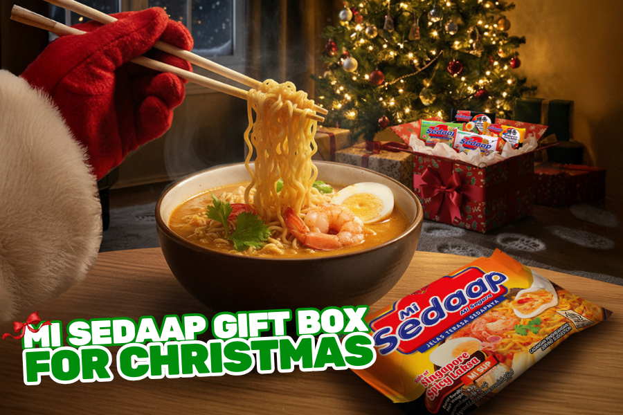 Mi Sedaap ramen bowl lifted with chopsticks beside Christmas gift box.